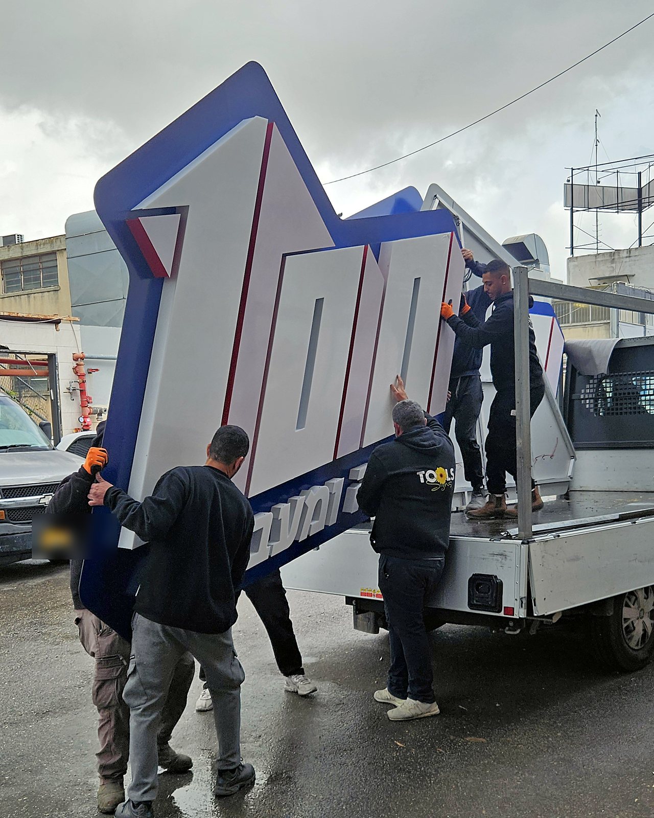 העמסת שלט חזית גדול על משאית לקראת התקנה