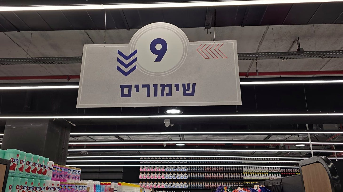 שלט מעבר ממוספר תלוי מהתקרה בסופרמרקט — מעבר 9 שימורים