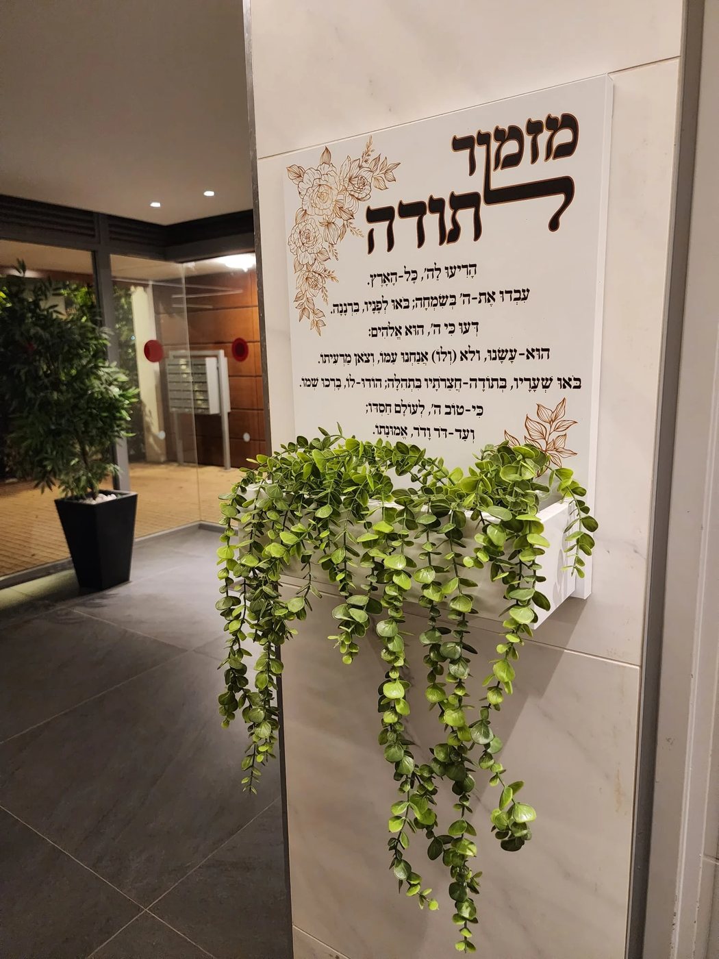 אדנית מדברת, מזמור לתודה בלבן, מותקנת בכניסה לבניין